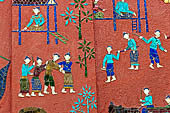 Wat Xieng Thong temple in Luang Prabang, Laos.  La Chapelle Rouge , the Red Chapel. The exterior walls are decorated with colourful mosaics on a pink background with scenes of people daily activities. North wall. 